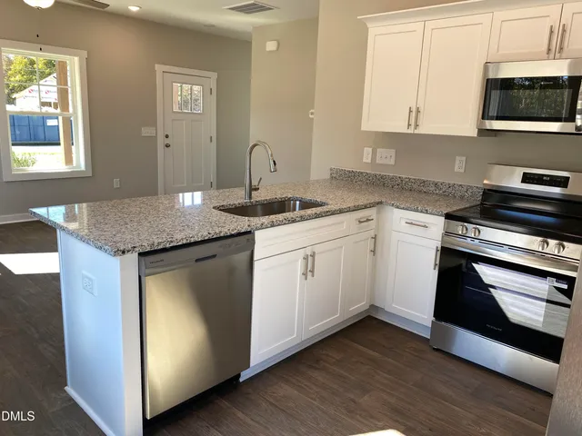 a kitchen with stainless steel appliances granite countertop a sink and a stove