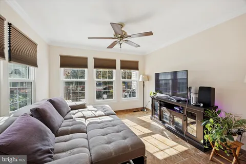a living room with furniture a flat screen tv and a floor to ceiling window