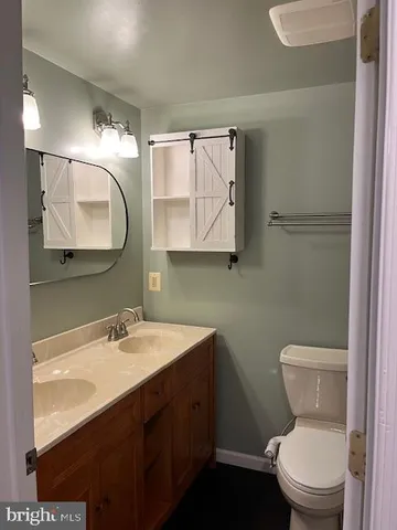 a bathroom with a toilet sink and mirror