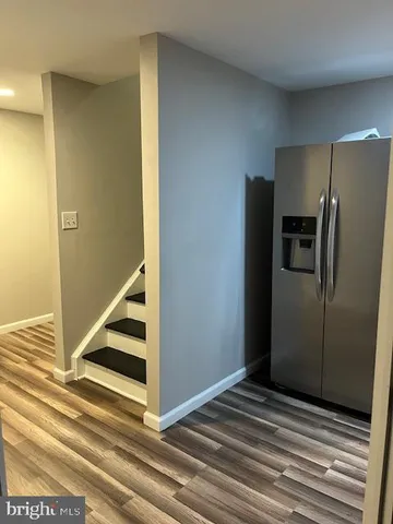 a view of a kitchen with wooden floor and a refrigerator