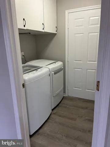 a utility room with washing machine and cabinets