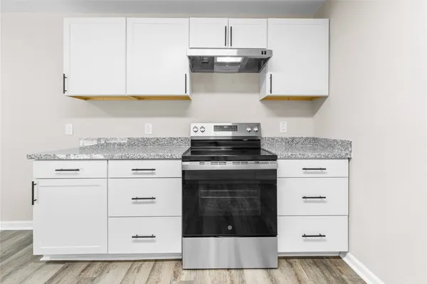 a kitchen with granite countertop a sink cabinets and stainless steel appliances