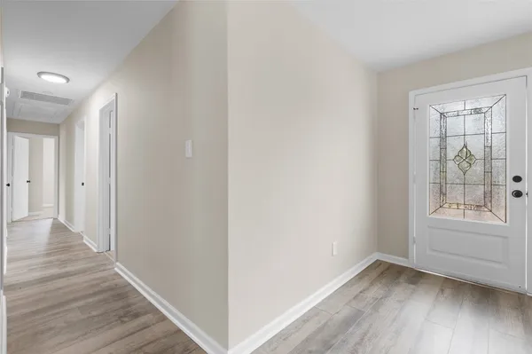 an empty room with a window and a fan