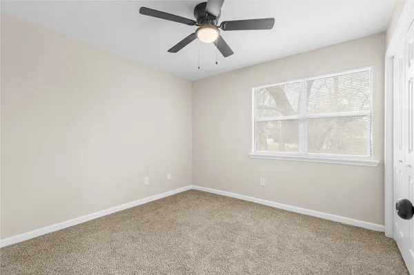 an empty room with chandelier fan