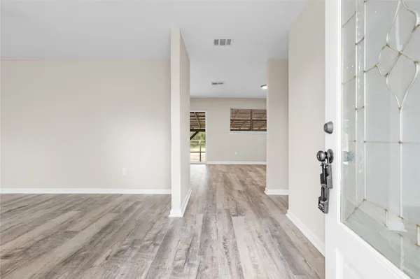 wooden floor in an empty room with a window