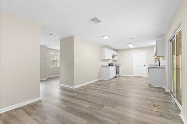 a view of a kitchen with a sink refrigerator and wooden floor