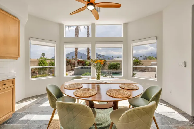 a dining room with furniture a chandelier and wooden floor