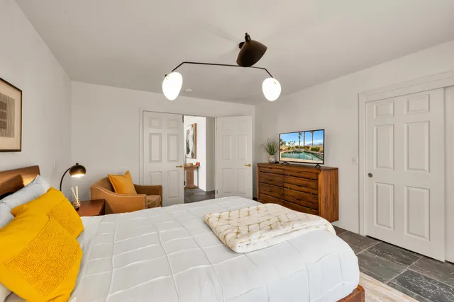 a bedroom with a bed and wooden floor