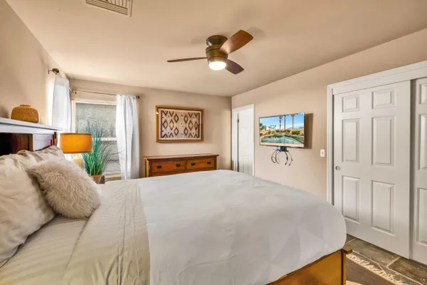 a bedroom with a large bed and a chandelier