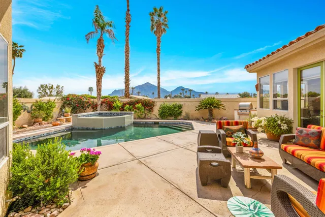 a view of a swimming pool with a yard and plants