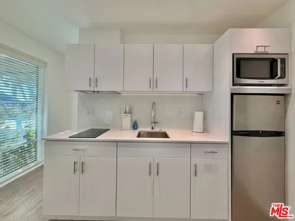 a kitchen with appliances a sink and cabinets