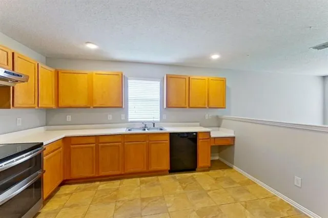 a kitchen with stainless steel appliances granite countertop a sink and a stove