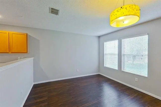 a view of a room with wooden floor and a window