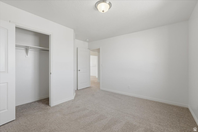 1218 Moonlight Drive Elk Ridge, UT 84651 - Photo 24 of 44 Unfurnished bedroom featuring light carpet and a closet