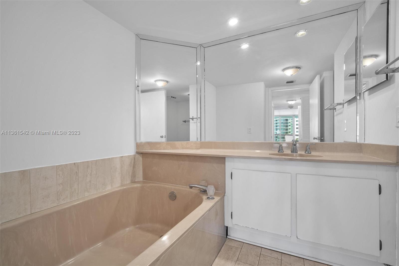 Omni Miami, FL 33132 - Photo 20 of 22 a bathroom with a granite countertop sink mirror and bathtub