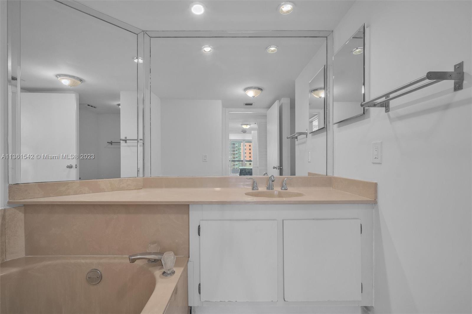 Omni Miami, FL 33132 - Photo 21 of 22 a bathroom with a granite countertop sink a toilet a mirror and shower