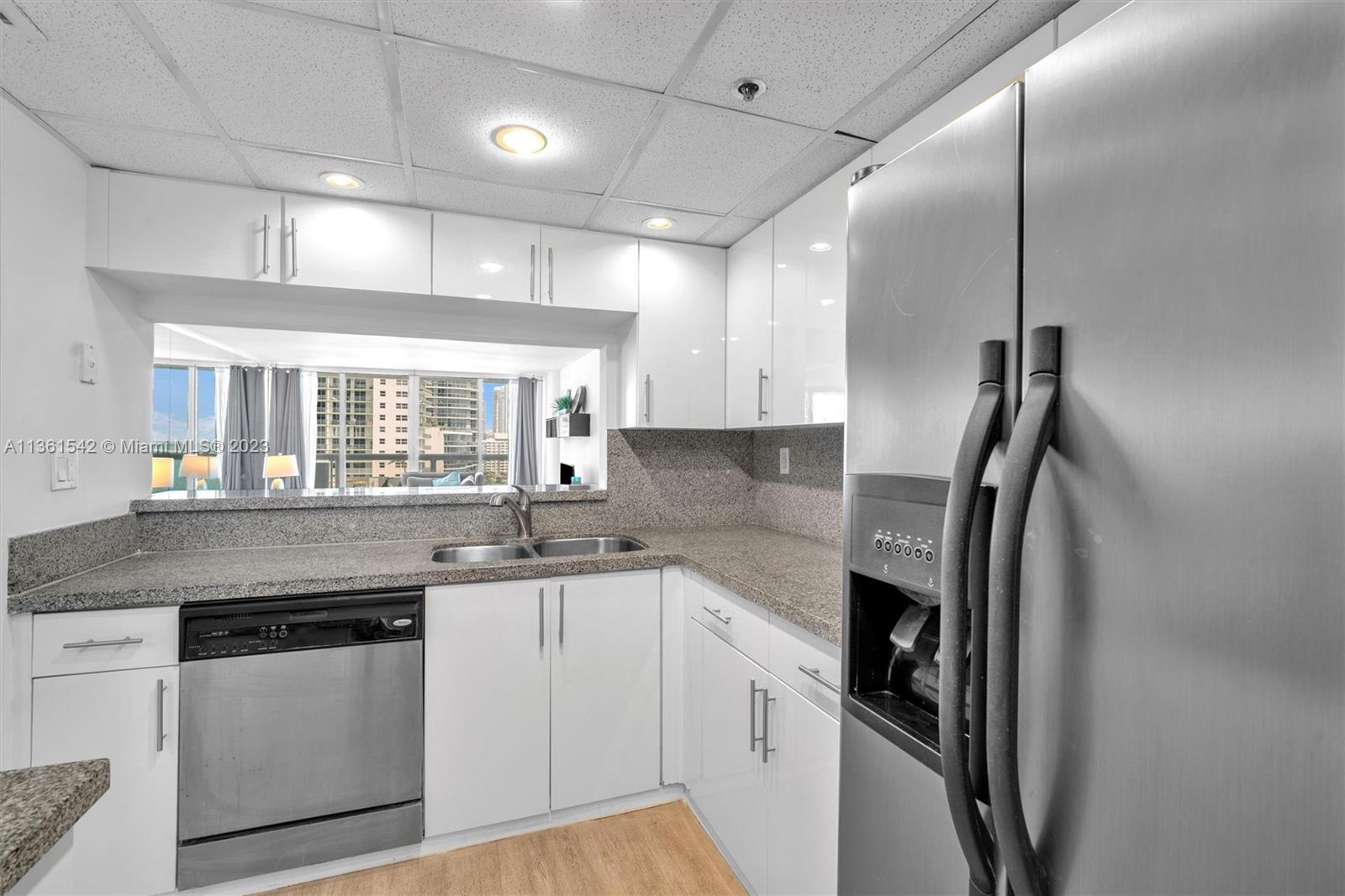 Omni Miami, FL 33132 - Photo 6 of 22 a kitchen with stainless steel appliances granite countertop a sink a stove a refrigerator and island with wooden floor