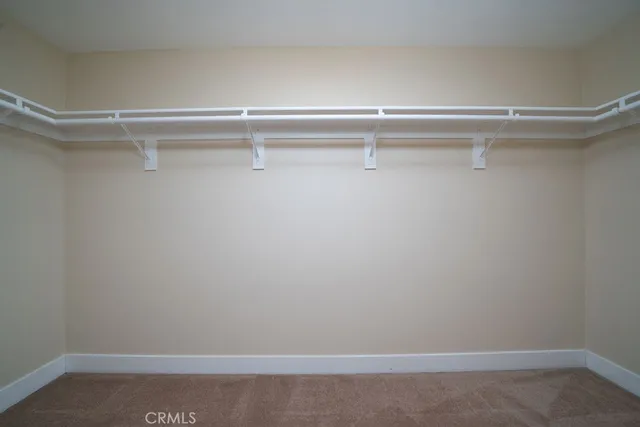 an empty room with ceiling fan and windows