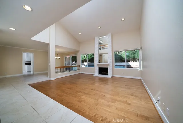 a view of an empty room with a fireplace and a window