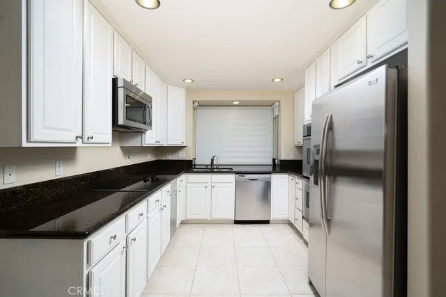 a kitchen with stainless steel appliances granite countertop a sink a stove a microwave and cabinets