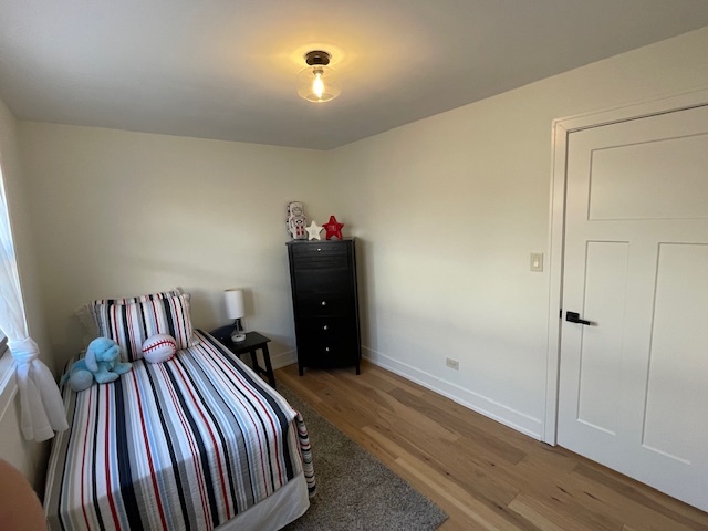 446 East 90th Street Chicago, IL 60619 - Photo 21 of 33 a bedroom with a bed and wooden floor