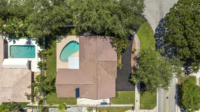 an aerial view of a house with a yard and a large tree