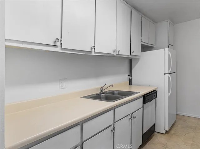 a kitchen with granite countertop white cabinets and a stove top oven