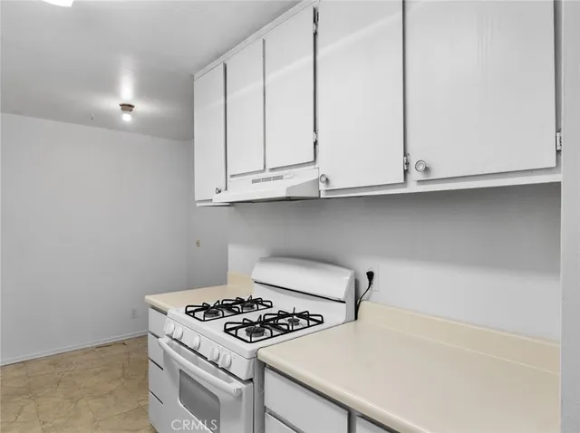 a kitchen with granite countertop a sink stove and cabinets