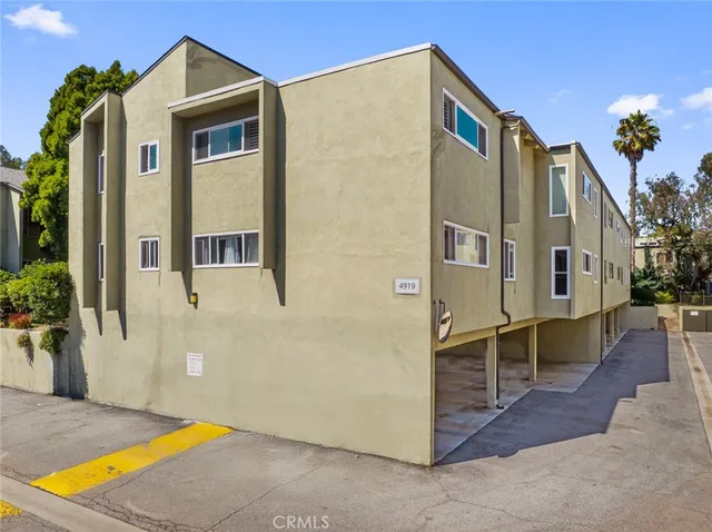 a large white kitchen with a stove a sink dishwasher and a fireplace with wooden floor