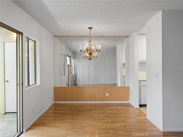 a view of a big room with wooden floor and windows