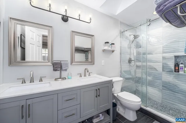 a bathroom with a double vanity sink toilet and shower
