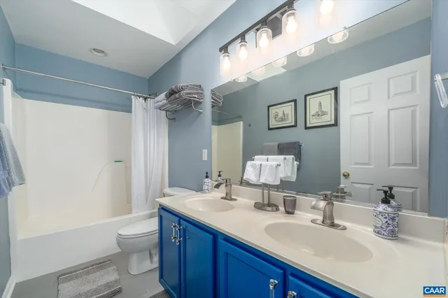 a bathroom with a double vanity sink mirror and toilet