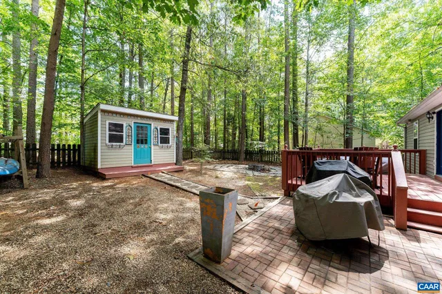 a view of a backyard with table and chairs and a large tree