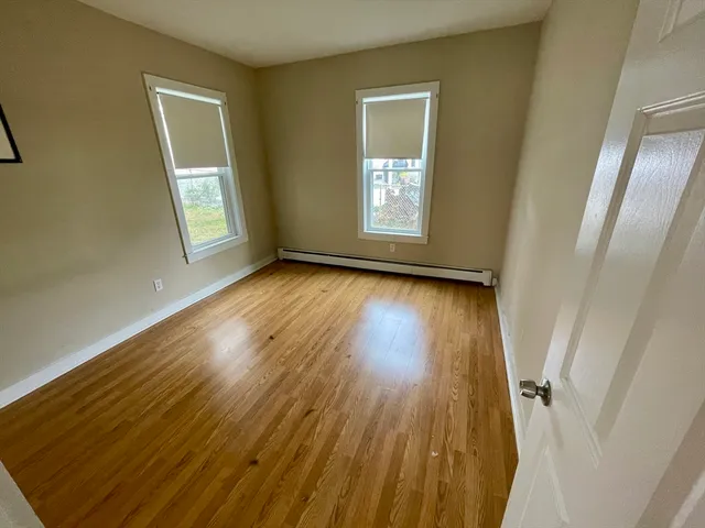 a view of a room with wooden floor and window