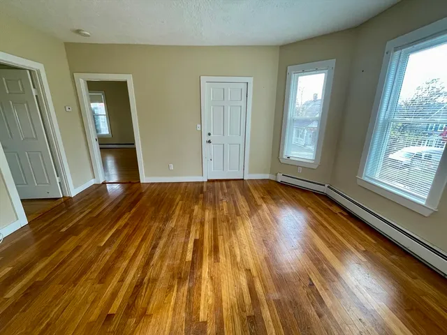 a view of a room with wooden floor and windows