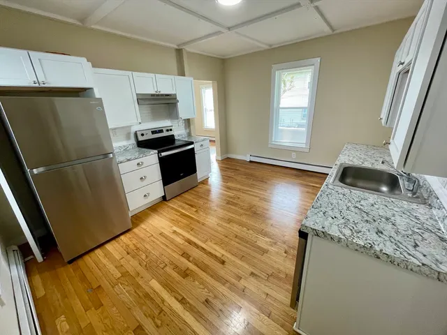 a kitchen with granite countertop a refrigerator and a sink