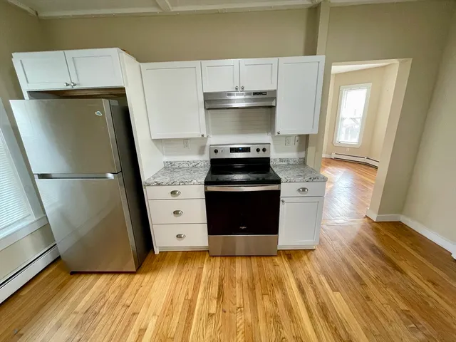 a kitchen with a sink and wooden floor