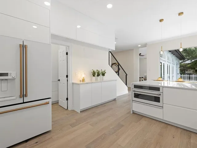 a view of an empty room with wooden floor and stairs