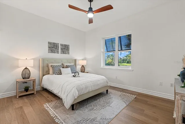 a bedroom with a bed large window and a lamp