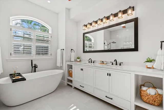 a bathroom with a tub a sink and a window