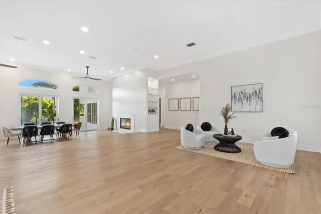 a view of a room with kitchen island a dining table chairs and a large window
