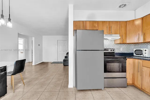 a kitchen with stainless steel appliances and refrigerator