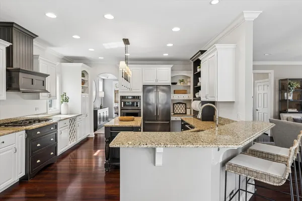 a kitchen with stainless steel appliances granite countertop a sink refrigerator and cabinets