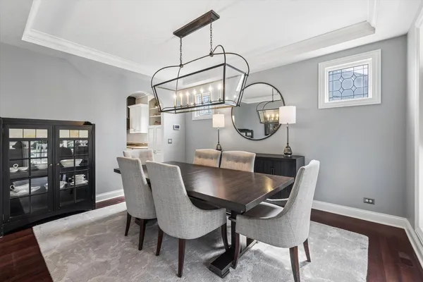 a dining room with furniture a chandelier and wooden floor