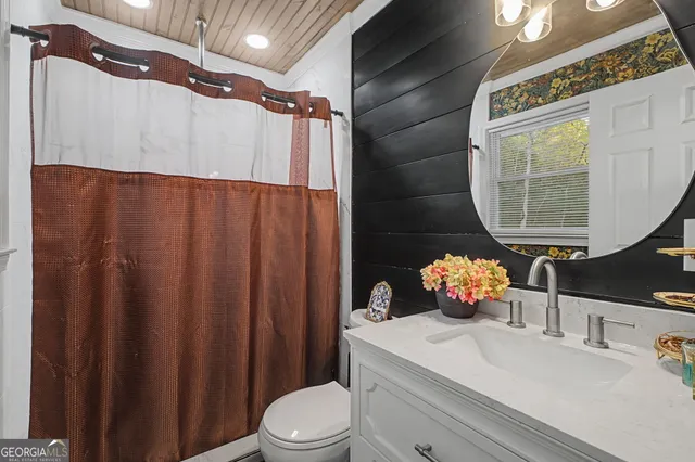 a bathroom with a sink vanity mirror and toilet