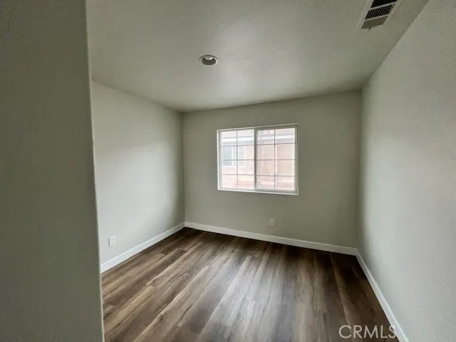 a view of a hallway with wooden floor and closet