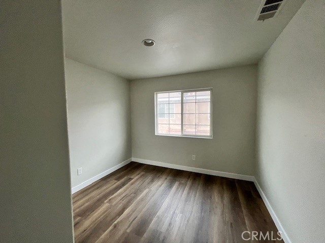 1004 South Riverside Avenue, Unit B2 Rialto, CA 92376 - Photo 11 of 14 an empty room with wooden floor and windows