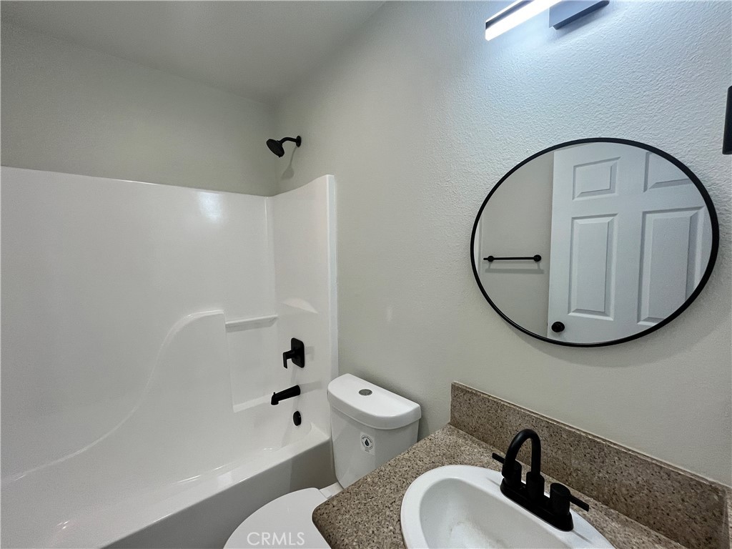 1004 South Riverside Avenue, Unit B2 Rialto, CA 92376 - Photo 13 of 14 a bathroom with a sink a toilet and a mirror