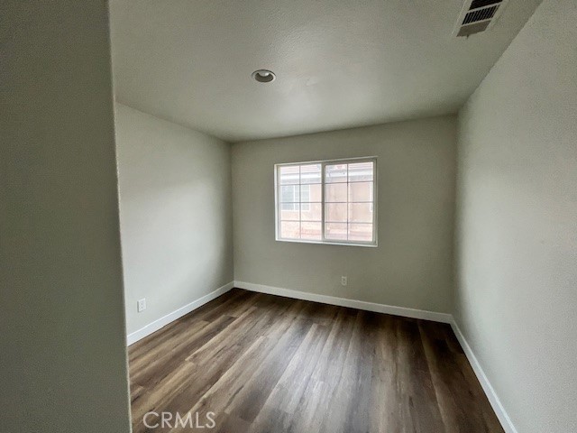 1004 South Riverside Avenue, Unit B2 Rialto, CA 92376 - Photo 10 of 14 an empty room with wooden floor and windows