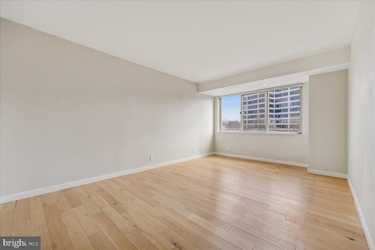 5600 Wisconsin Avenue, Unit 705 Chevy Chase, MD 20815 - Photo 21 of 62 a view of an empty room with wooden floor and a window